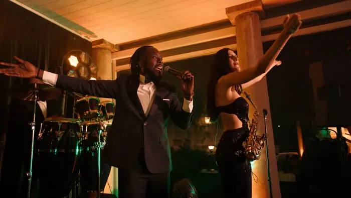 An R&B singer performing at a wedding party, backed by vocalists and musicians | Mikevents