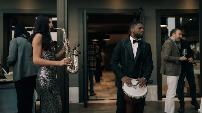 Two musicians, a saxophonist and a percussionist, play at a wedding during the cocktail hour as guests mingle | Mikevents