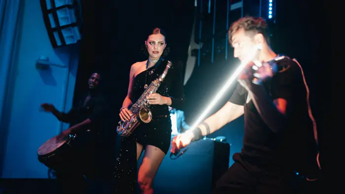 A violinist, a double bass player and a saxophonist on stage at a corporate event in an elegant setting | Mikevents