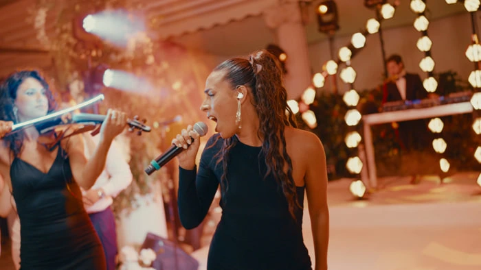 A singer performing at a wedding | Mikevents