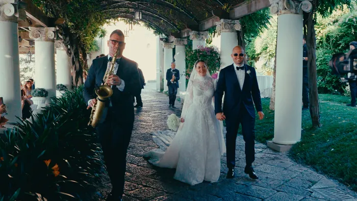A couple walking in under a pergola to live saxophone | Mikevents