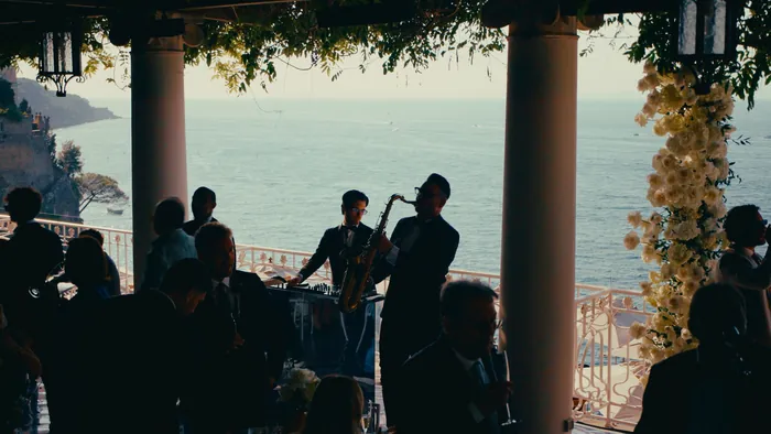 Saxophonist and keyboardist playing on a terrace overlooking the sea during cocktail hour | Mikevents